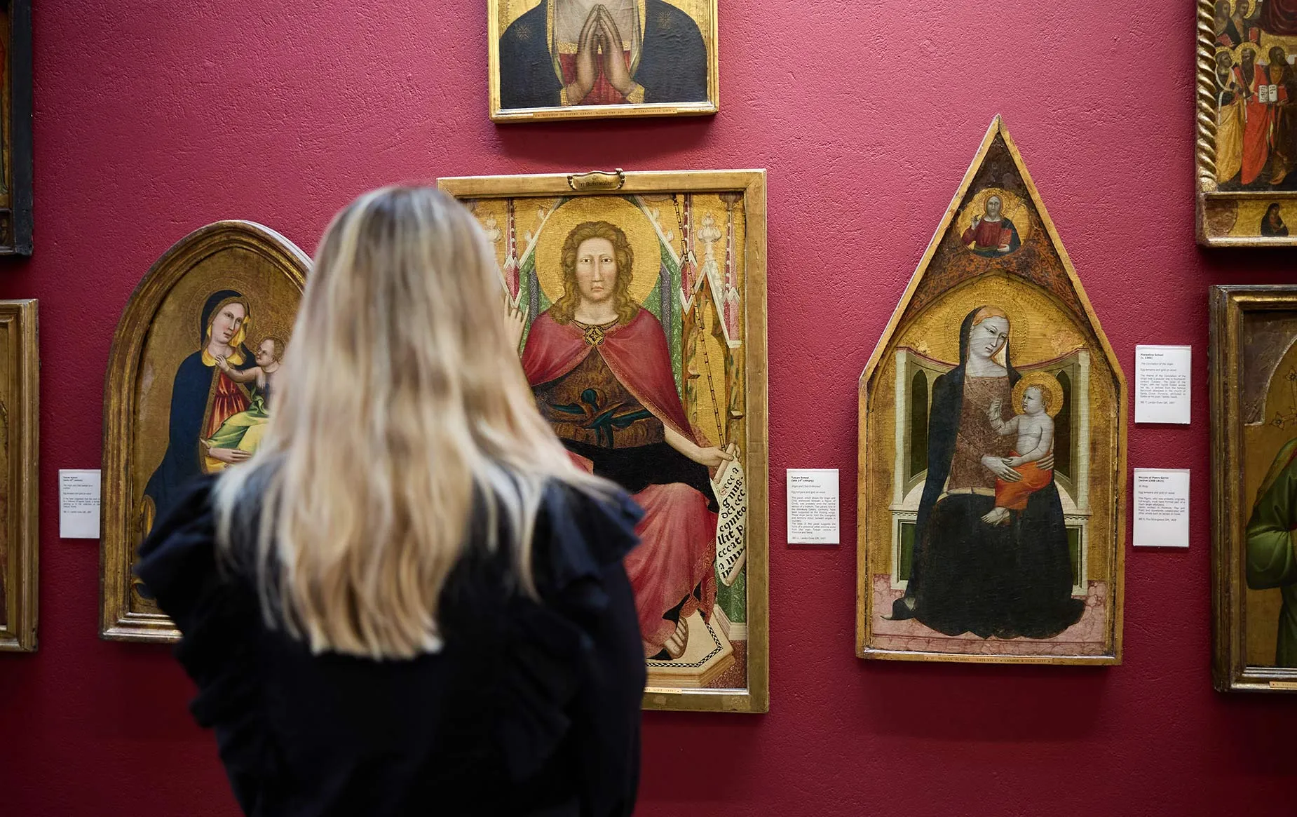 A visitor viewing paintings from the collection